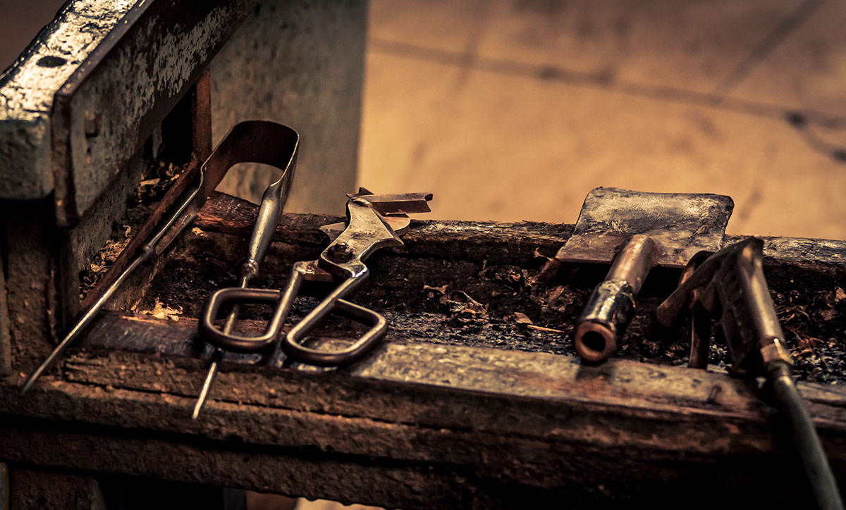 A close up image of a workbench and glassblowing tools.